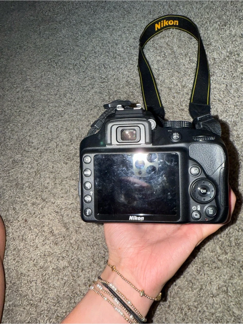 Nikon Black DSLR with Zoom Lens and Branded Neck Strap